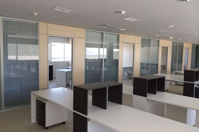 Esempio di realizzazione di allestimento ufficio operativo con pareti diviorie in vetro della linea Covert e complementi d'arredo
